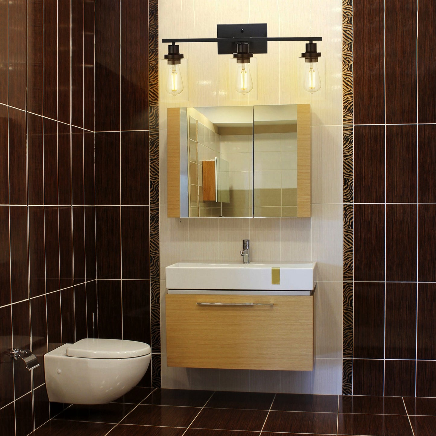 Black vanity sconce installed in an entryway beside a decorative mirror