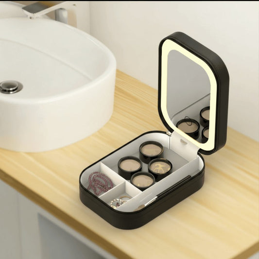 Black travel makeup bag with LED mirror open on bathroom vanity shelf