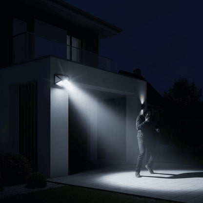 Person walking past solar wall light triggering PIR motion sensor in dark outdoor area